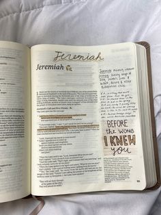 an open book with writing on it sitting on top of a white bed spreader