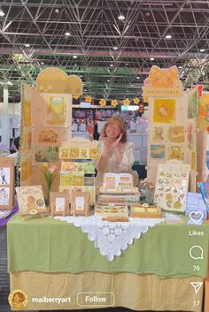 a woman standing behind a table covered in greeting cards