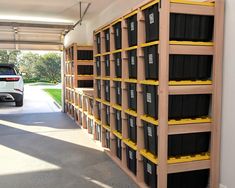 a car is parked in the garage next to some shelves with bins on them