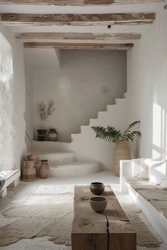 a living room with white walls and carpeted flooring next to a stair case