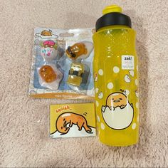 a yellow water bottle sitting on top of a white carpet next to two small toys