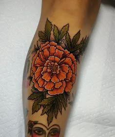 a woman's leg with an orange flower on top of her head and face