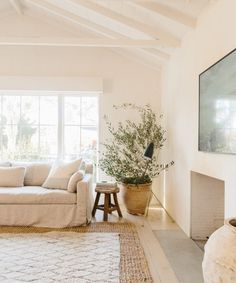 a living room with white furniture and a large window