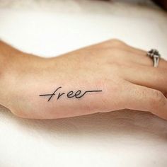 a woman's hand with a small tattoo saying free