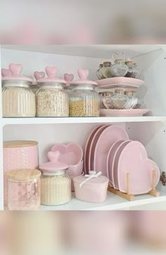 the shelves are filled with pink dishes and plates