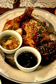 a white plate topped with meat and dipping sauces