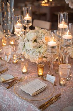 the table is set with candles and place settings for an elegant dinner or reception party