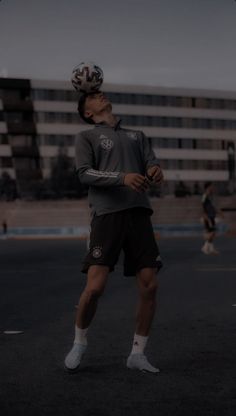 a man standing in the middle of a parking lot wearing a bicycle helmet and shorts