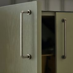 an open cabinet door with handles on both sides and a drawer in the other side