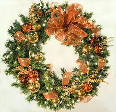 a christmas wreath with orange and gold ornaments