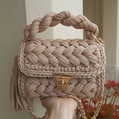 a handbag with a chain attached to it on a white tableclothed surface