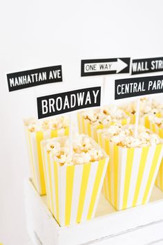 popcorn in striped paper cups with street signs on top and directional signs for each cupcake