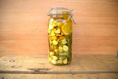 a jar filled with yellow and green vegetables