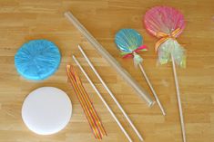 some lollipops are sitting on the floor next to chopsticks and paper plates