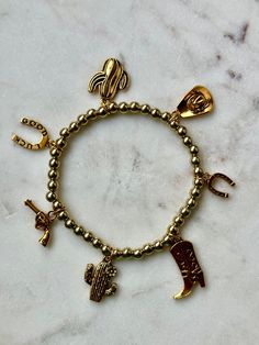 Western-themed Elastic Charm Bracelet featuring your favorite Western accessories! Adjustable Novelty Charm Bracelet, Adjustable Novelty Charms Bracelets, Casual Metal Charm Bracelet As Gift, Casual Metal Charm Bracelet For Gift, Casual Metal Charm Bracelet Gift, Adjustable Gold Casual Wristband, Adjustable Gold Wristband Casual Style, Casual Gold Stretch Bracelet For Gift, Casual Gold Stretch Bracelet Gift