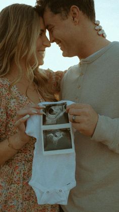 a man and woman are holding an old photo