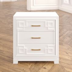 a white chest of drawers sitting on top of a hard wood floor