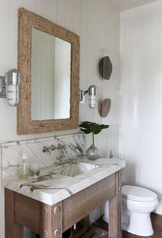 a bathroom with two sinks and a mirror on the wall next to a white toilet