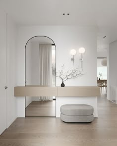 a white room with a mirror, stool and vase on the floor in front of it