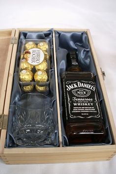 two bottles of whiskey and some chocolates in a wooden box