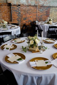 the table is set with gold plates and place settings for guests to sit down at