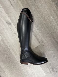 a pair of black boots sitting on top of a wooden floor