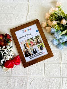 a photo frame sitting on top of a white tile floor next to flowers and a bouquet