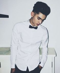 a young man wearing a white shirt and bow tie