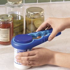 a person using a plastic container to open the lid on a jar