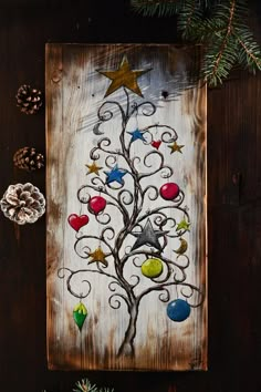 a christmas tree painted on wood with ornaments around it