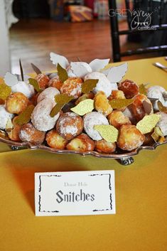 a bowl filled with donuts sitting on top of a yellow tablecloth covered table