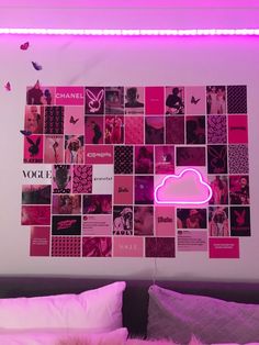 a bed with pink sheets and pillows in front of a wall that has pictures on it