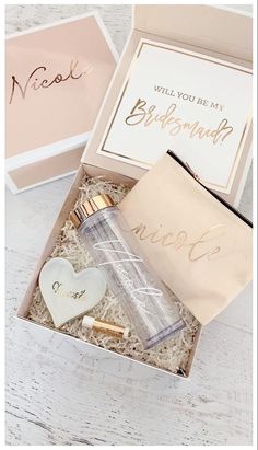 an open gift box with personalized items inside on a white wooden table next to it