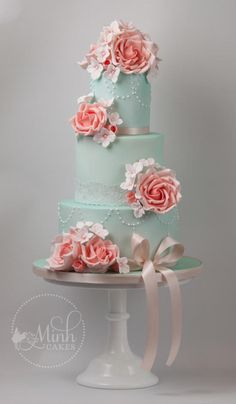 a three tiered cake with pink flowers on top