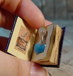 a miniature book with a blue glass bottle in it