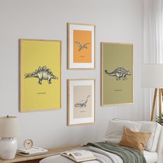 three framed pictures hang on the wall above a bed in a room with white walls