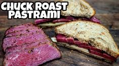 a cut in half sandwich sitting on top of a wooden cutting board with the words chuck roast pastrami