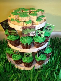 cupcakes are stacked on top of each other with green frosting and decorations