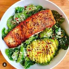 a white bowl filled with salad and salmon