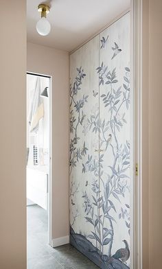 an open door leading to a hallway with wallpaper