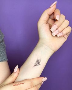 a woman's arm with a small bird tattoo on the left side of her wrist