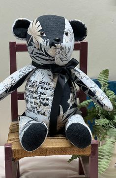 a stuffed animal sitting on top of a wooden chair next to a potted plant