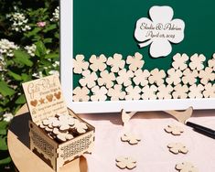 a table topped with wooden cut outs and paper flowers next to a card box filled with cards