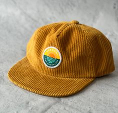 This is a KIDS size hat!  Adjustable back strap but probably fits toddler to 8year olds best. If your kid has an adult size head this hat may be too small.  Fun mustard yellow corduroy with our original Lake Champlain Vermont patch sewn on in our Vermont studios Flat brim, metal adjustable tab in back Unstructured 100% cotton Yellow Adjustable Flat Bill Snapback Hat, Adjustable Yellow Hat With Flat Bill, Yellow Adjustable Snapback Hat With Flat Brim, Yellow Adjustable Snapback Baseball Cap, Adjustable Yellow Snapback Hat, Adjustable Yellow Snapback Cap, Yellow Adjustable Flat Brim Snapback Hat, Casual Gold Flat Bill Hat, Yellow Baseball Cap With Flat Bill