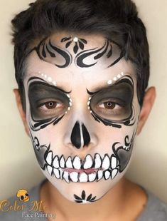 a young boy with black and white face paint