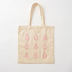 a tote bag with pink and red trees printed on the front, sitting on a white surface