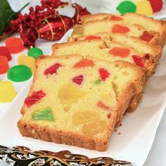 slices of fruit cake on a white plate next to a cup of coffee and candy