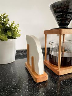 a wooden stand with a coffee maker and potted plant