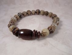 "Rustic stacking bracelet in olives, beiges, browns and cream in 8mm carved jade beads with large agate and brown 6mm shell rondels.    As with any dyed Jade, keep away from water.  Bracelet is 7.25\".   See more of my stackers and other bracelets: https://www.etsy.com/shop/HermitDesignsJewelry?section_id=14126986&ref=shopsection_leftnav_1" Bracelets Layering, Bracelets Gemstone, Layering Bracelets, Druzy Bracelet, Stack Bracelet, Stacking Bracelets, Brown Bracelet, Carved Jade, Bohemian Bracelets