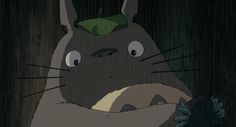 a cartoon character holding an umbrella in front of a dark background with the caption totoro